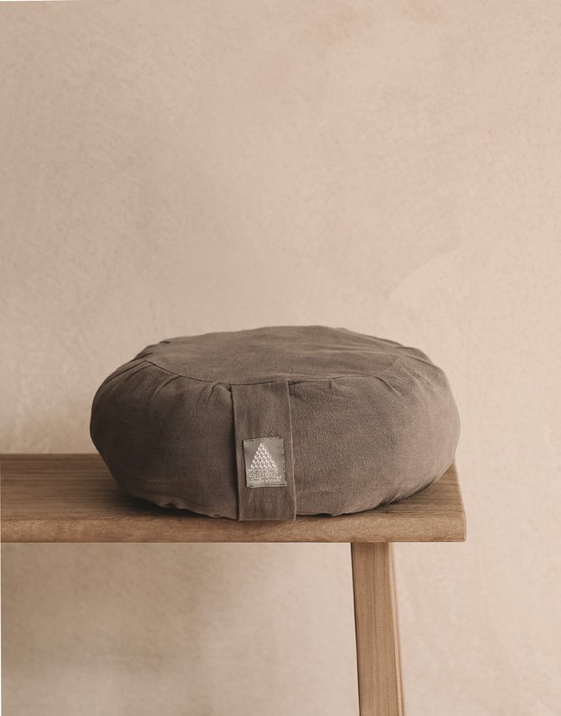 Zafu meditation cushion in graphite hemp linen on a bench