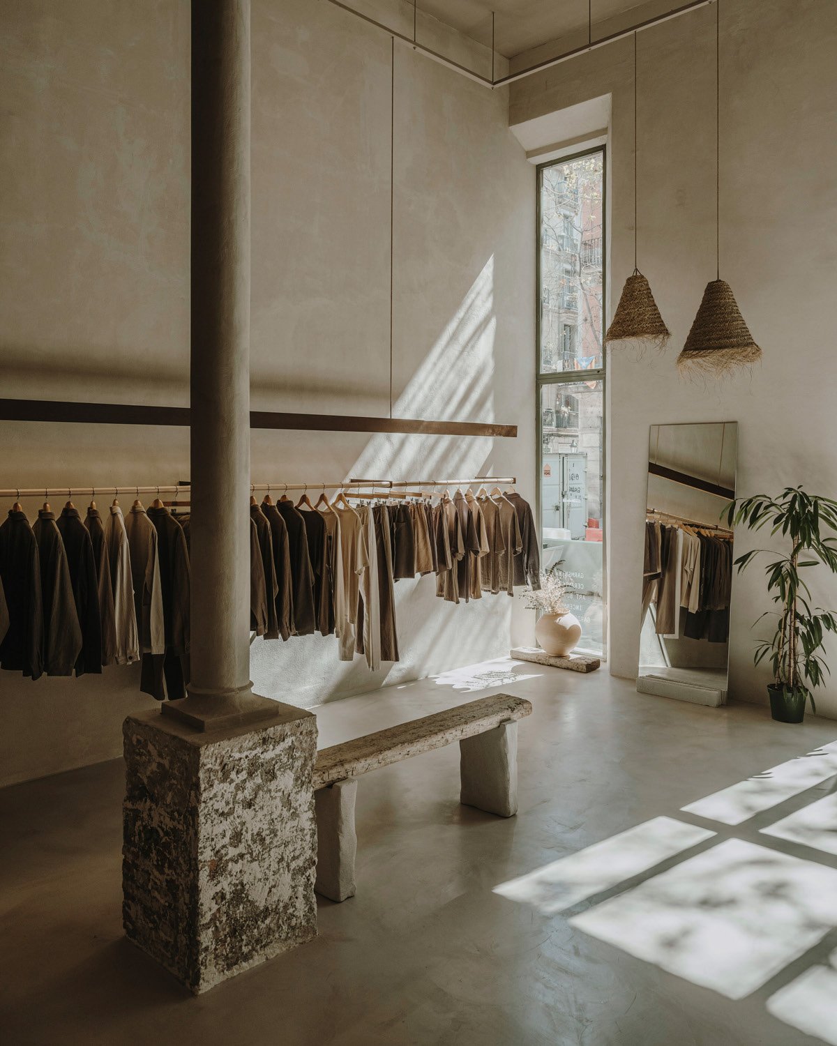 Clothing rail and bench beside a stone-clad column