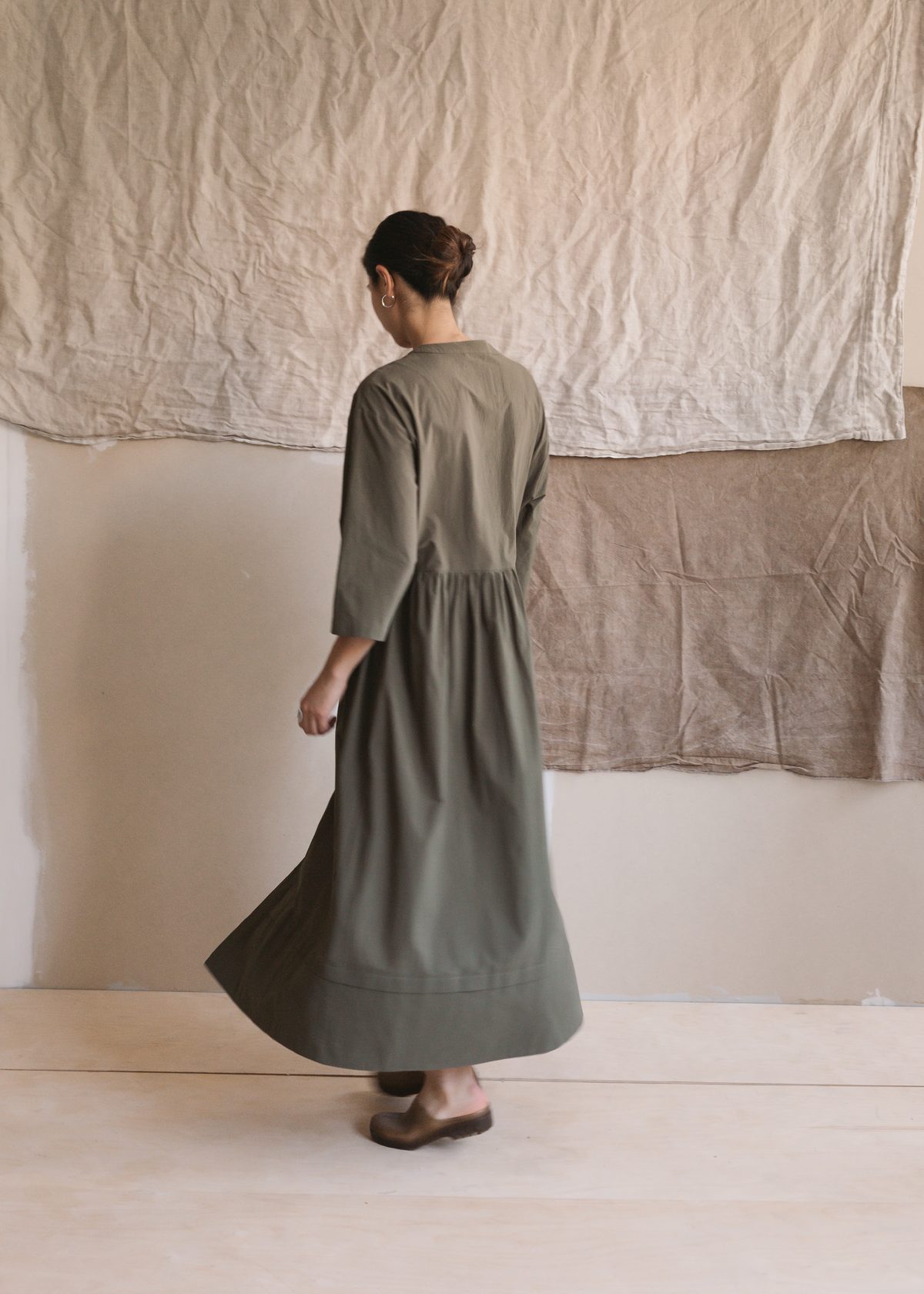 Olive gathered dress in motion, from behind